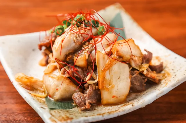 牛タンと牡蠣をキムチで炒めたピリ辛な一品