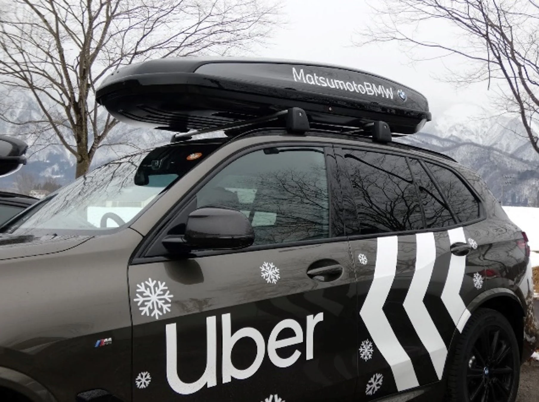 Uberの雪の結晶ラッピングとMatsumotoBMWルーフボックスを搭載したBMW車両の側面