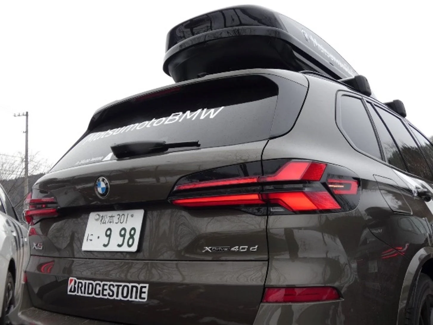 ブリヂストン製スタッドレスタイヤとMatsumotoBMWルーフボックスを搭載したUberライドシェアBMW車両の後部