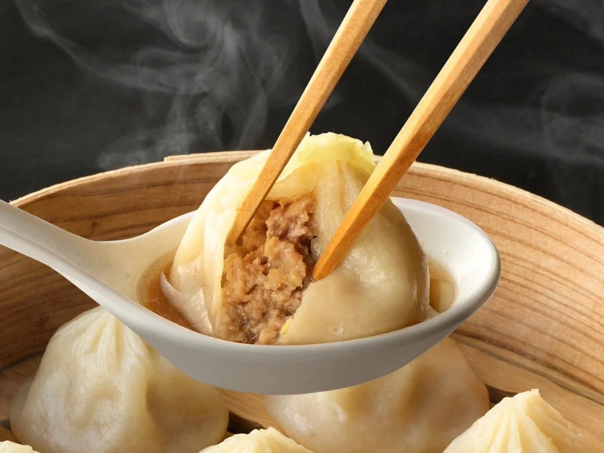 箸で持ち上げられた熱々の小籠包