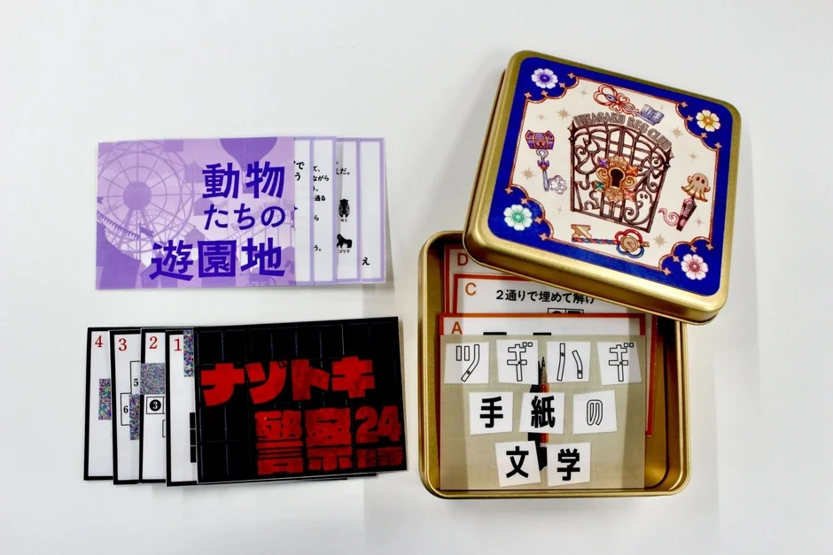 ひかがくヒラメキBOXの缶と謎解き用紙の内容物