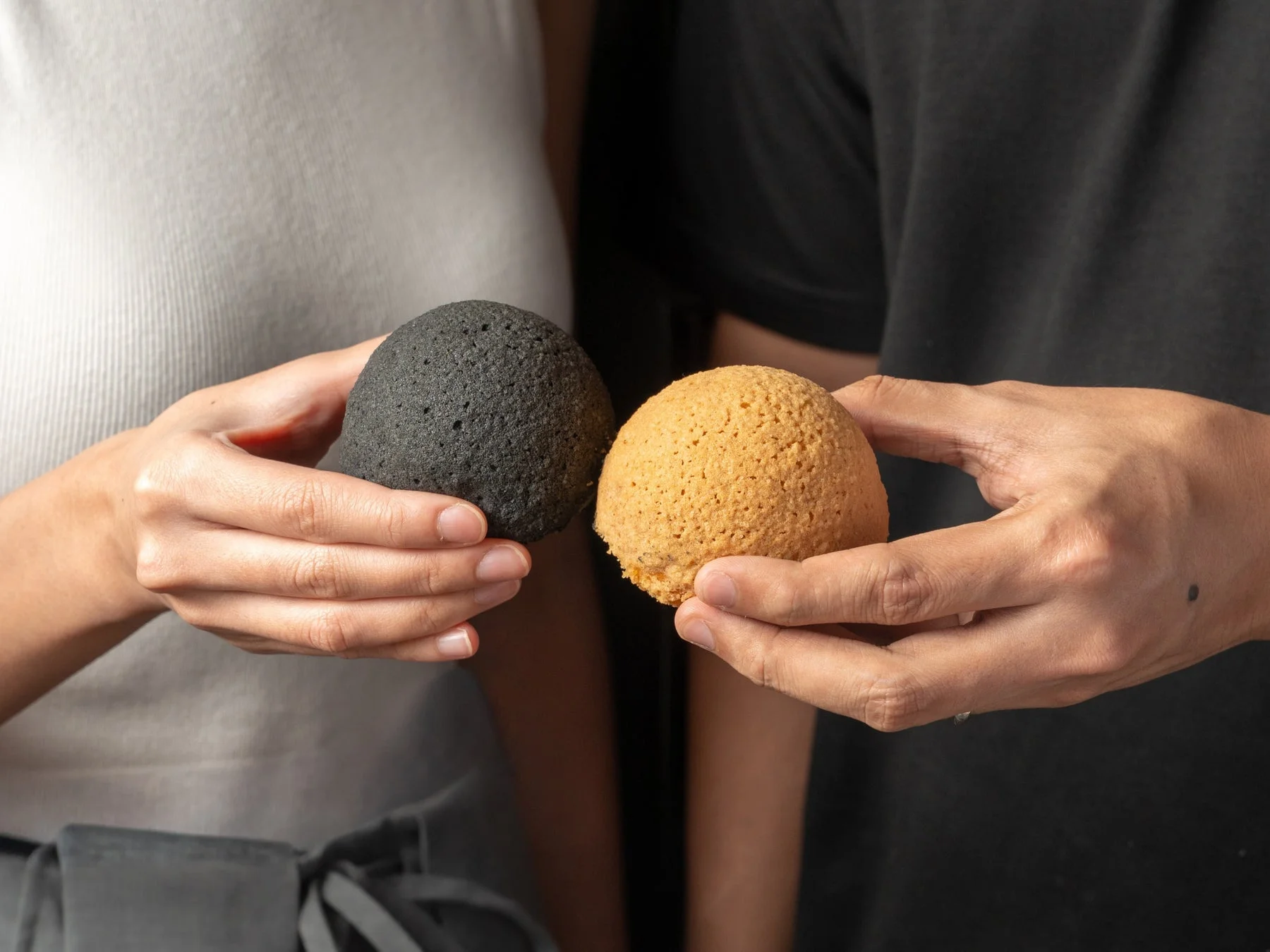 黒トリュフチキンバオとベイクドチャーシューバオを持つ手