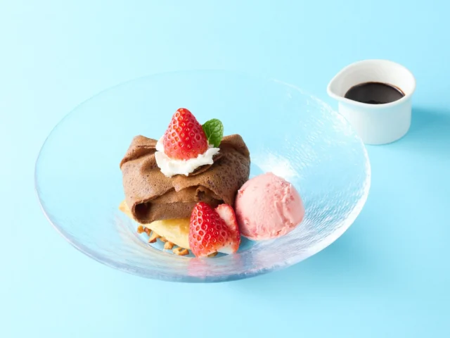 いちごとチョコのクレープパイ。ホットチョコソースが添えられている。