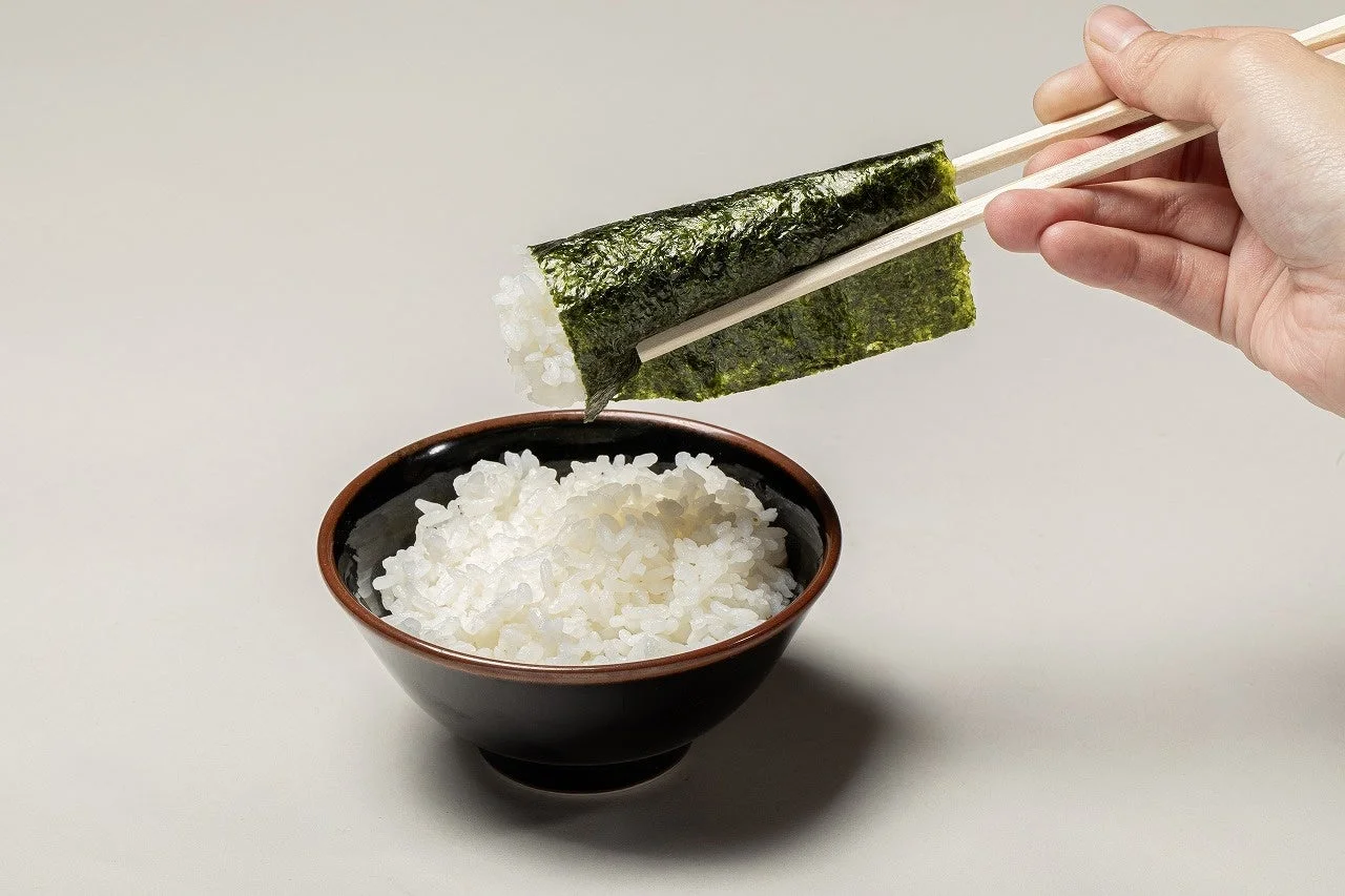 横浜家系ラーメン大和家で海苔で巻いたご飯を食べる様子