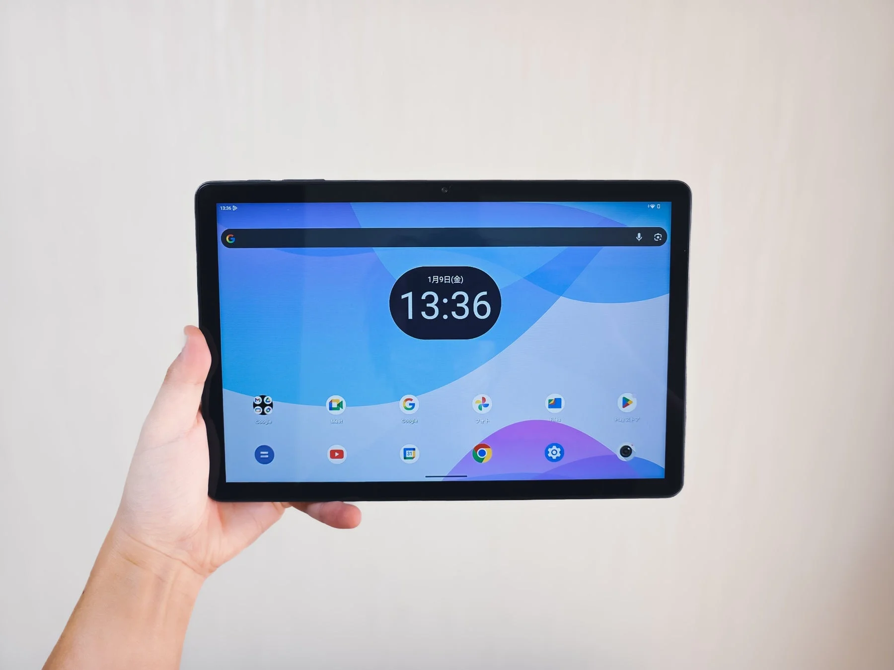 Tabwee T50タブレットを手に持った様子。Android 16のホーム画面が表示されている。