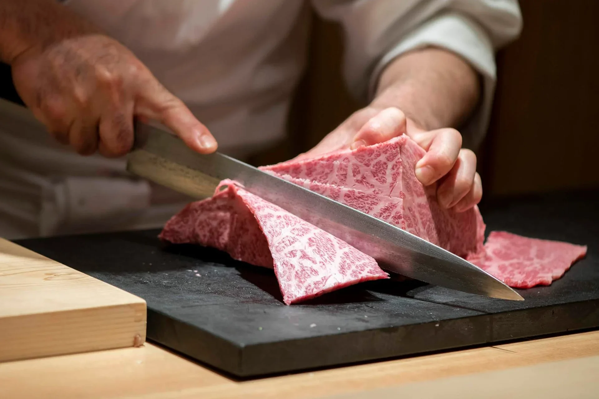 職人が丁寧に和牛の塊をカットしている様子