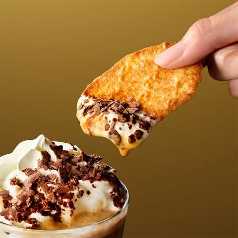 ワッフルクッキーをカカオ エスプレッソ アフォガート フラペチーノ®にディップする様子