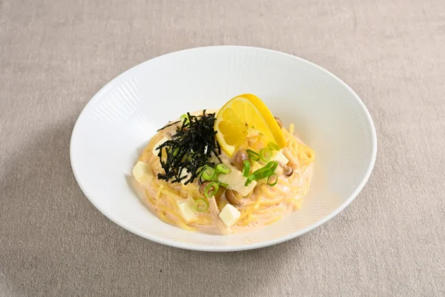 レモンが添えられたとろけるタラコモッツアレラパスタ