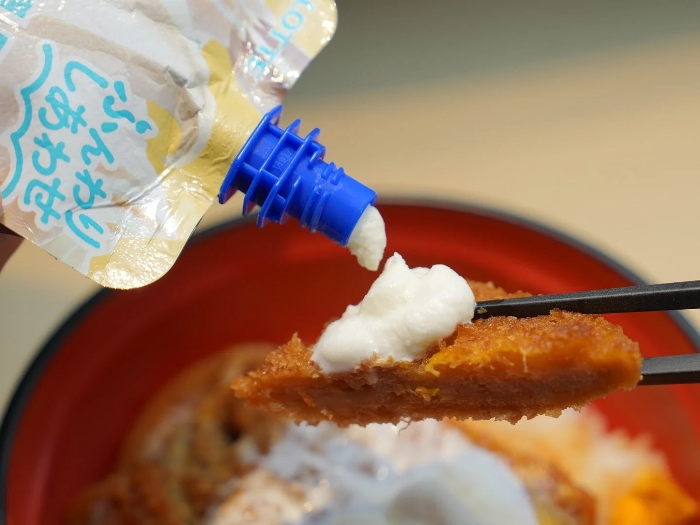 「クーリッシュ ホイップクリーム」をかけたかつを箸で持ち上げる様子