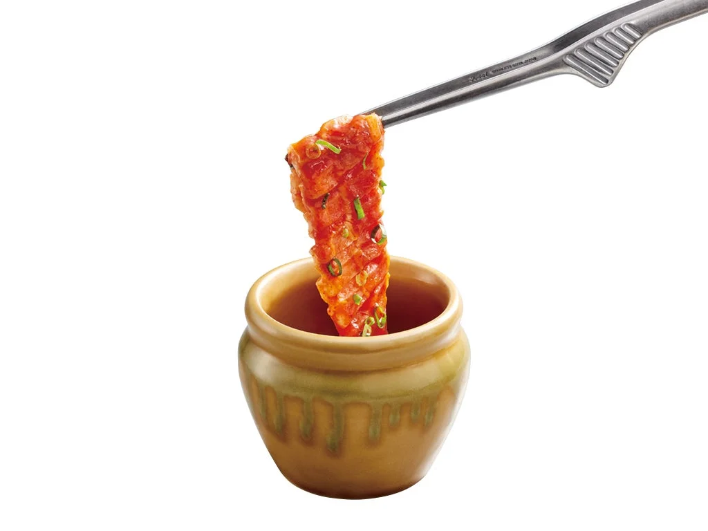 壺漬けすだれ豚バラカルビをトングで持ち上げる様子