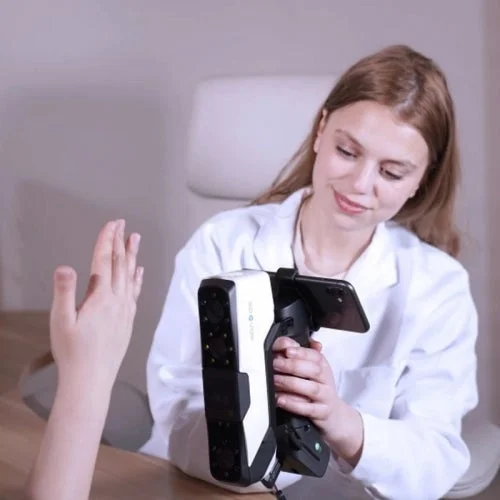 3DeVOK Airgoを装着した3Dスキャナーを女性が使用し、手のひらをスキャンする様子。