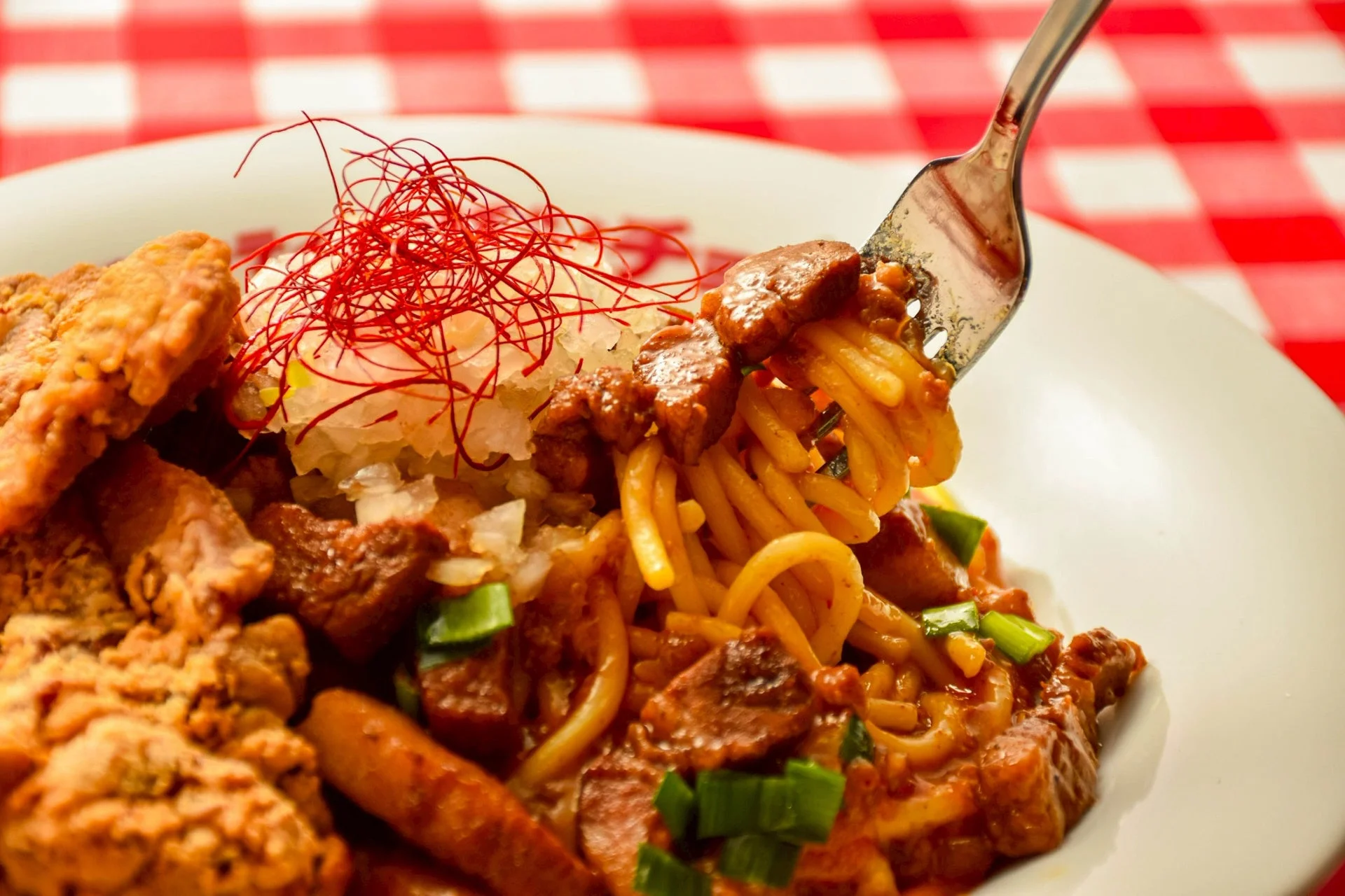 フォークで麺を持ち上げる「肉！麺！酒！これが本気のさちよ盛り」の接写