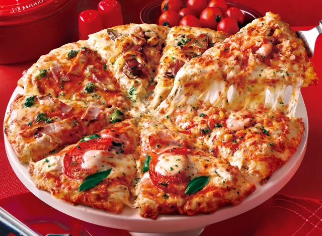 紅ズワイのフィッシャーマンズを含む冬のプレミアムクォーターピザ、チーズが伸びる様子