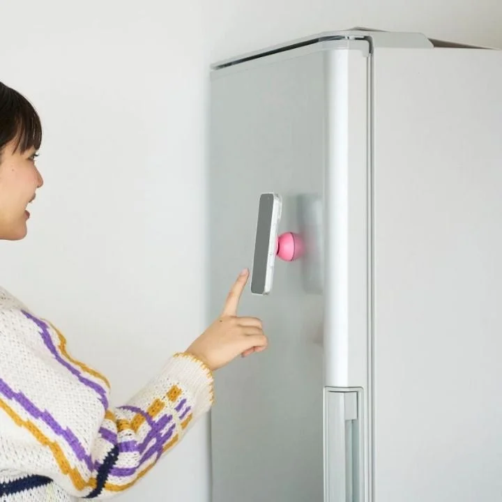 冷蔵庫にモバピタselfieで固定されたスマホを見る女性