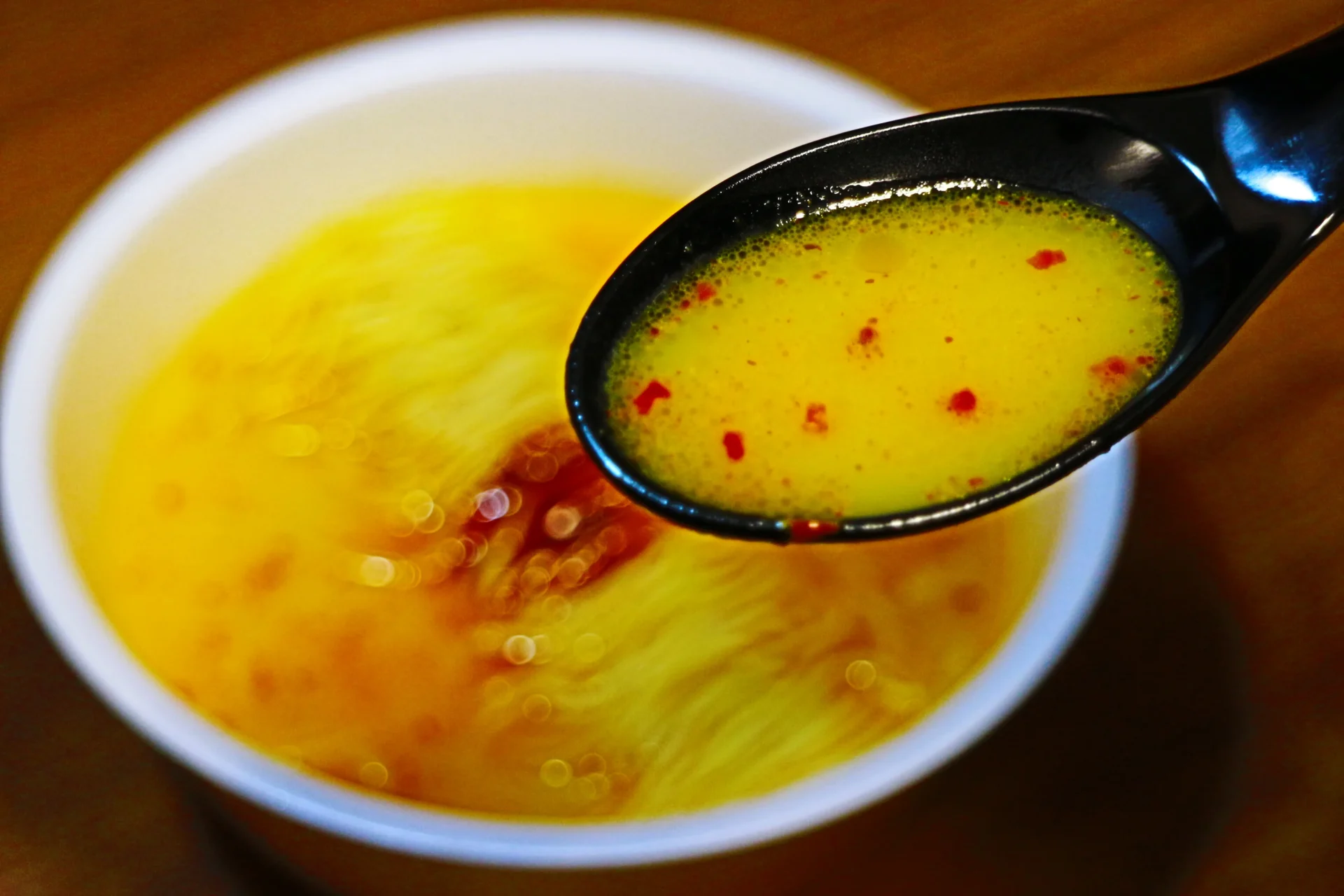 スプーンですくわれた「一蘭とんこつ炎」の旨辛とんこつスープ