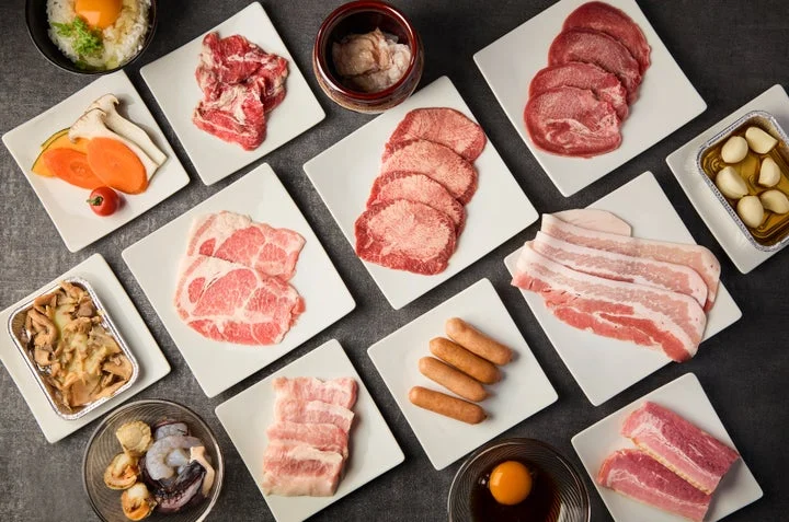 様々な部位の肉とサイドメニューが並ぶ焼肉食べ放題の光景