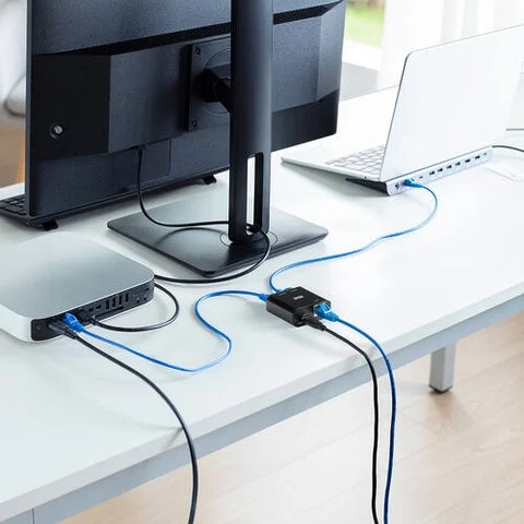 デスク上のパソコンと周辺機器に接続された超小型スイッチングハブ