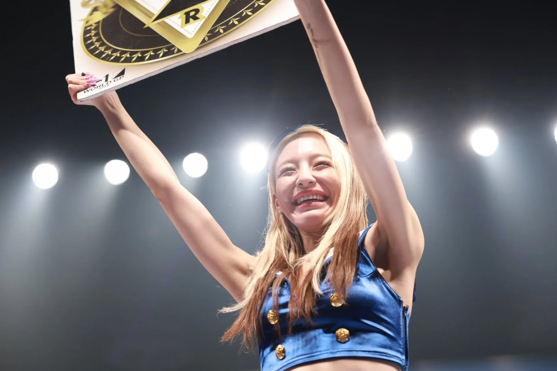 ラウンドボードを掲げ笑顔を見せるスペシャルラウンドガールの鈴木ユリアさん