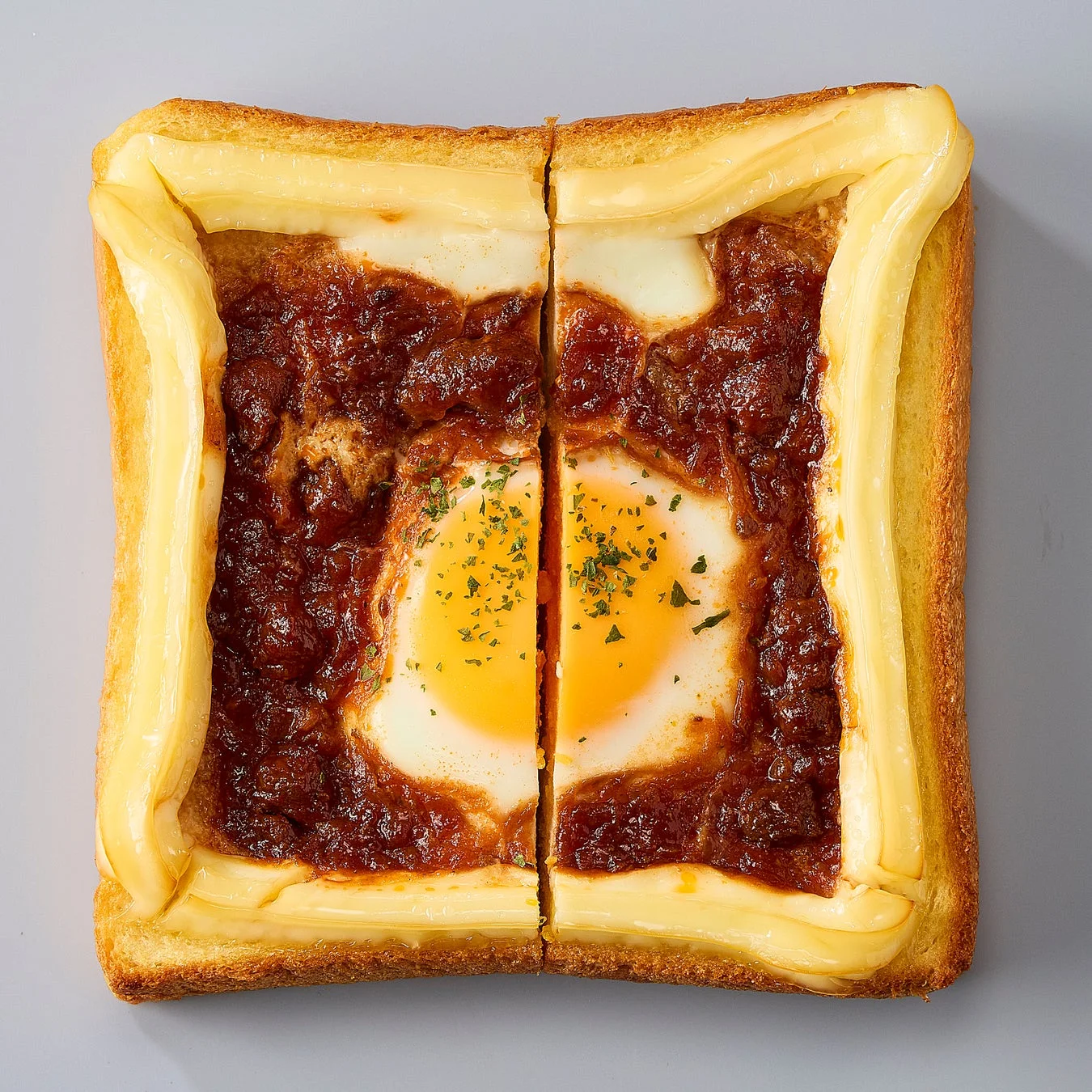 半分にカットされた、ボロネーゼソースと卵が乗ったあさごぱん