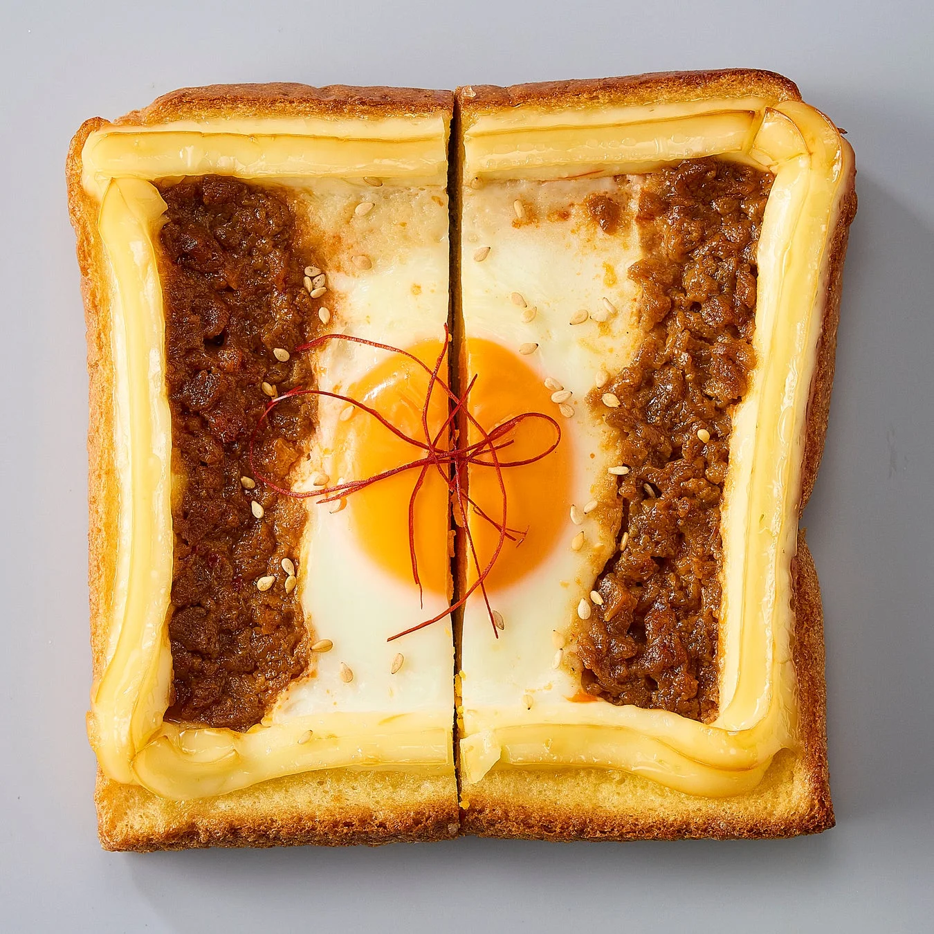 半分にカットされた、坦々ソースと卵が乗ったあさごぱん