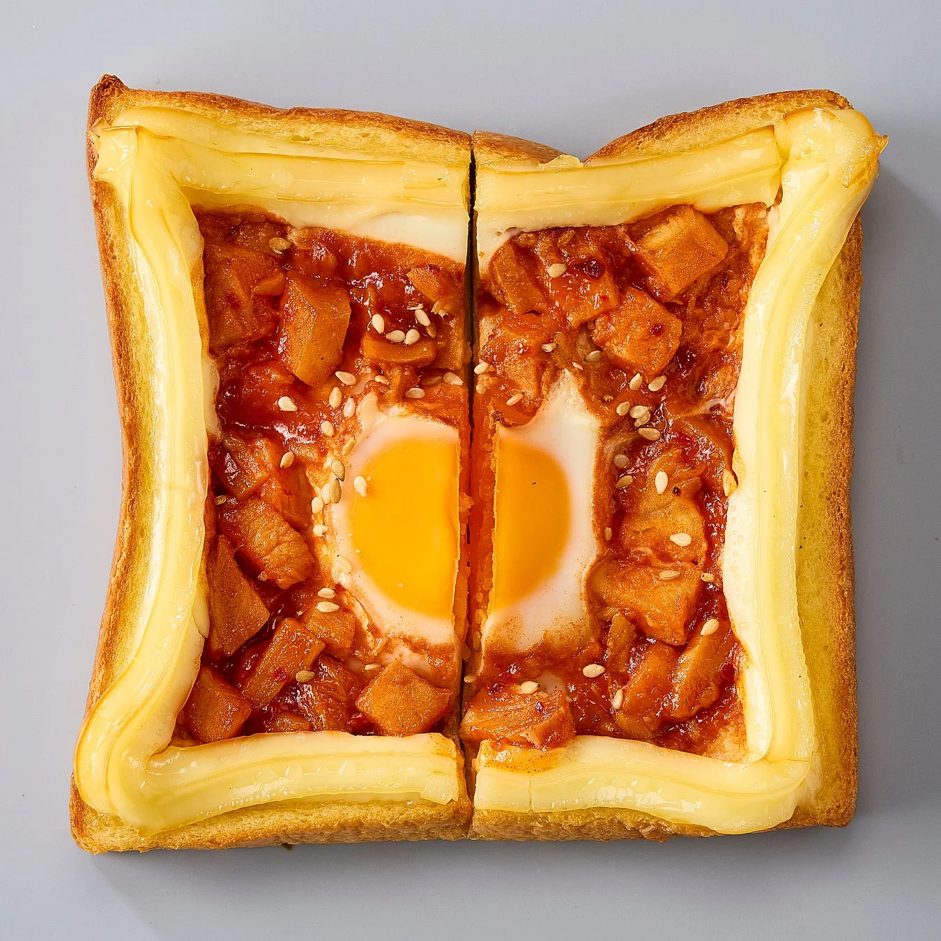 半分にカットされた、ヤンニョムチキンと卵が乗ったあさごぱん