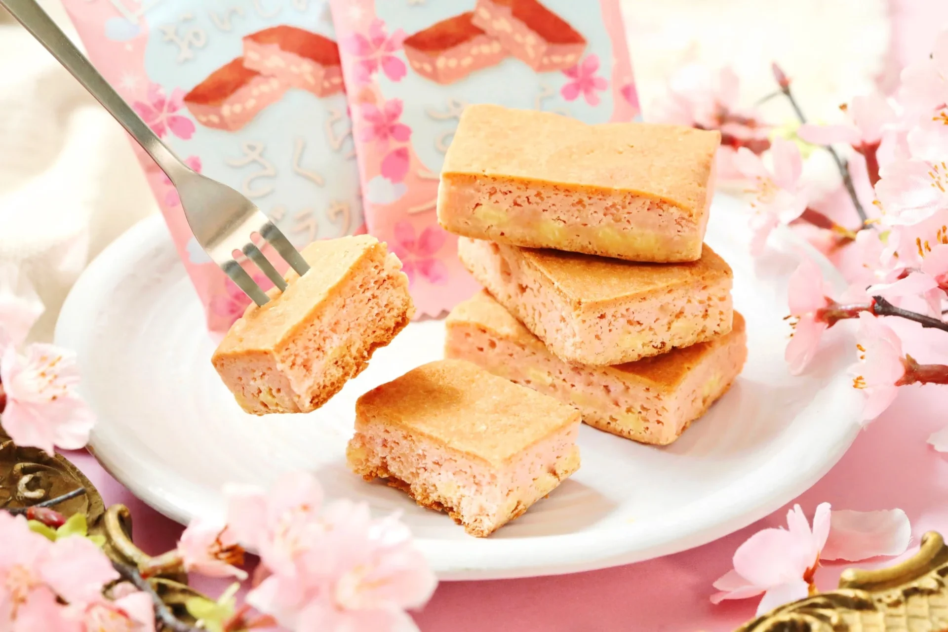 フォークで持ち上げられた世にもおいしいさくらブラウニーとパッケージ、桜の花