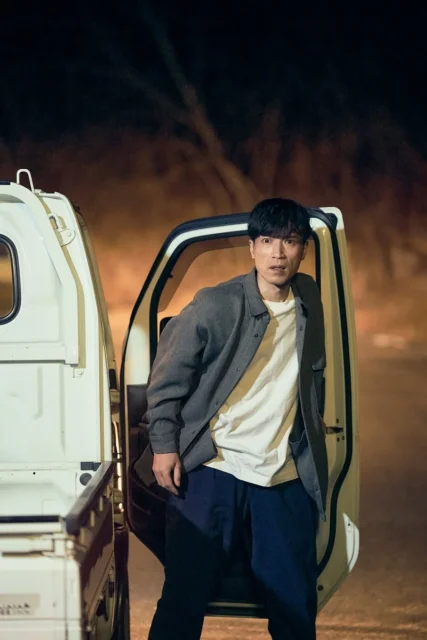 車から降りて周囲を警戒する鬼川治男（半田周平）