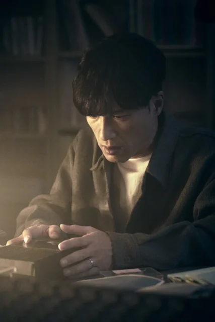 カセットテープを操作する鬼川治男（半田周平）