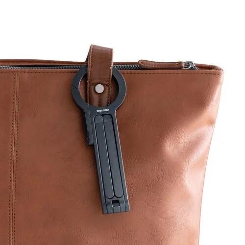 折りたたんでバッグの持ち手に取り付けられたスマホ三脚スタンド