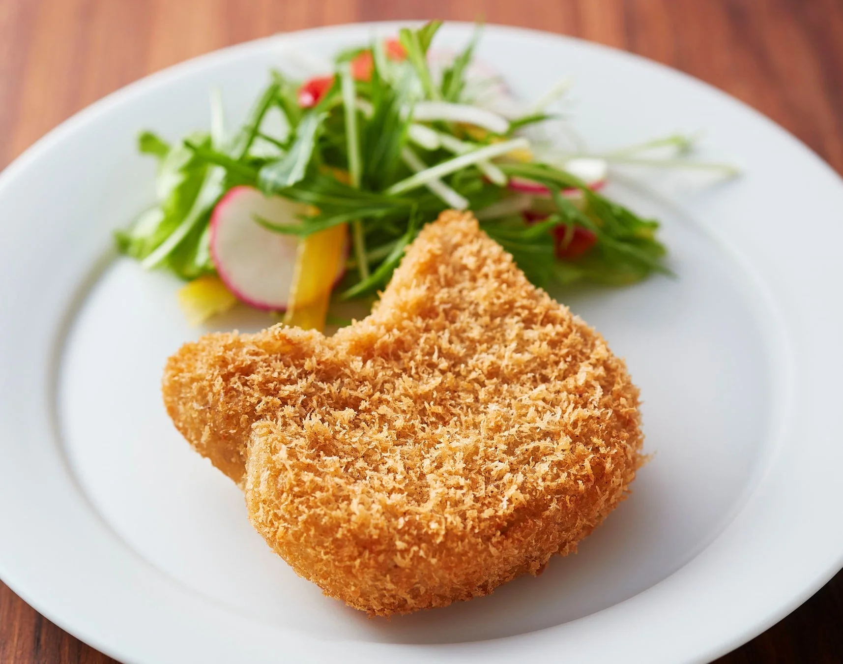 お皿に盛り付けられた神戸コロッケの「にゃんこロッケ」とサラダ