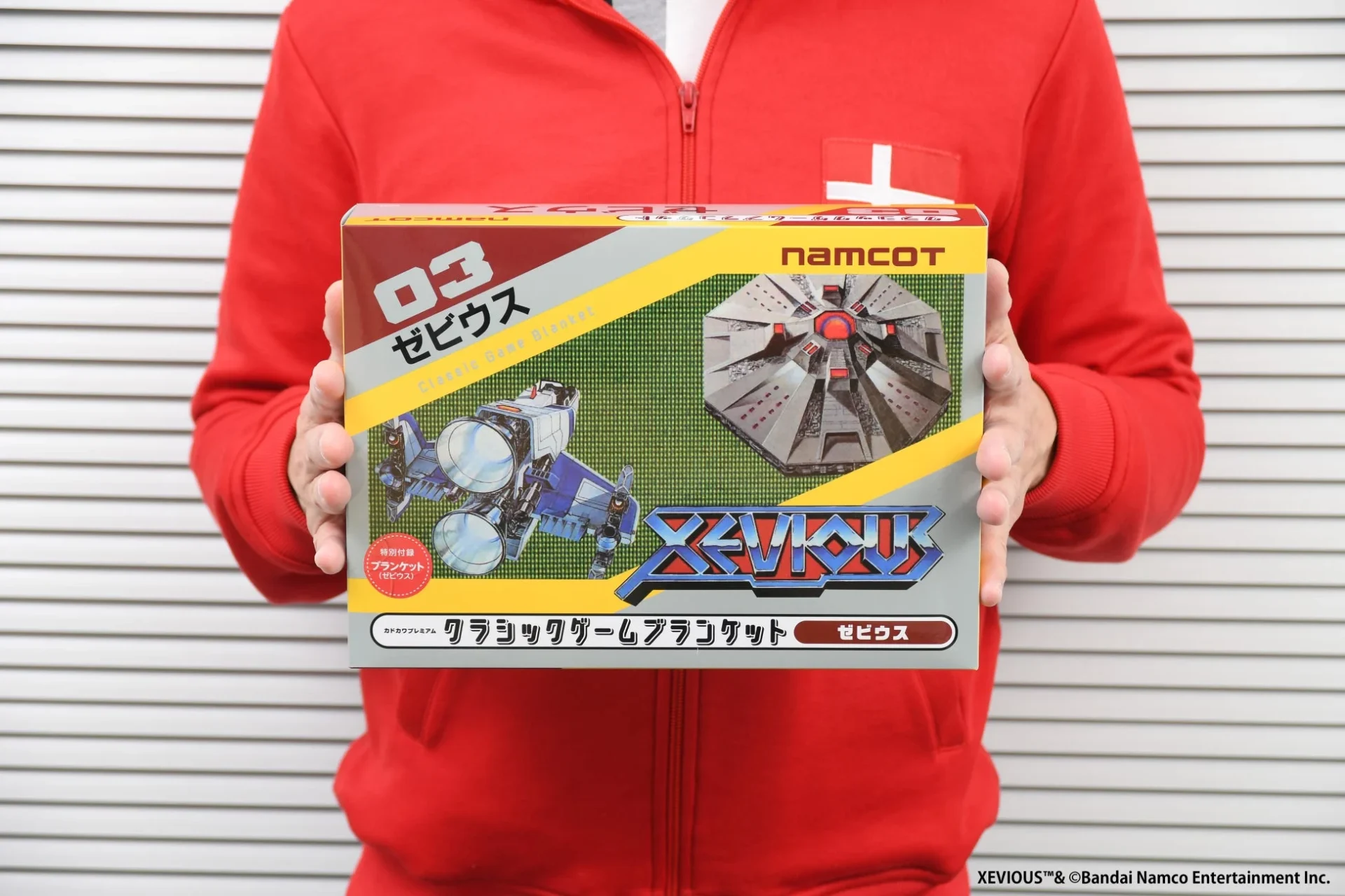 人物が持つクラシックゲームブランケット「ゼビウス」のパッケージ