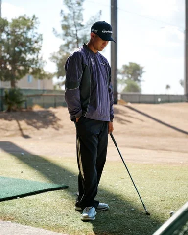 ゴルフ練習場でウィンドブレーカーを着用するゴルファー