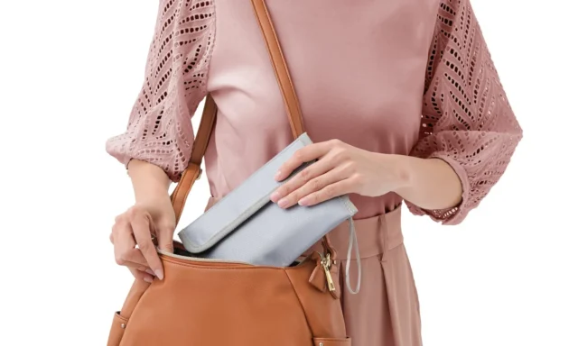 「あんしん耐火ポーチ」をバッグに入れる女性の様子。