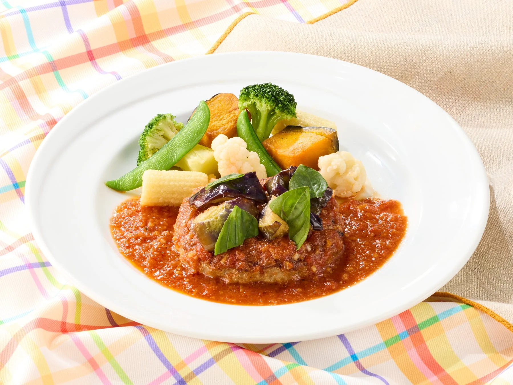 ココスの「揚げなすとバジルのガーリックトマトハンバーグ」。揚げなすとフレッシュバジルが添えられたハンバーグ。