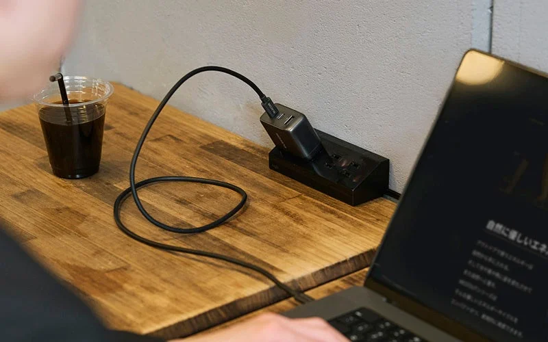 エレコムのコンパクトなAC充電器がコンセントに接続されノートPCを充電している様子
