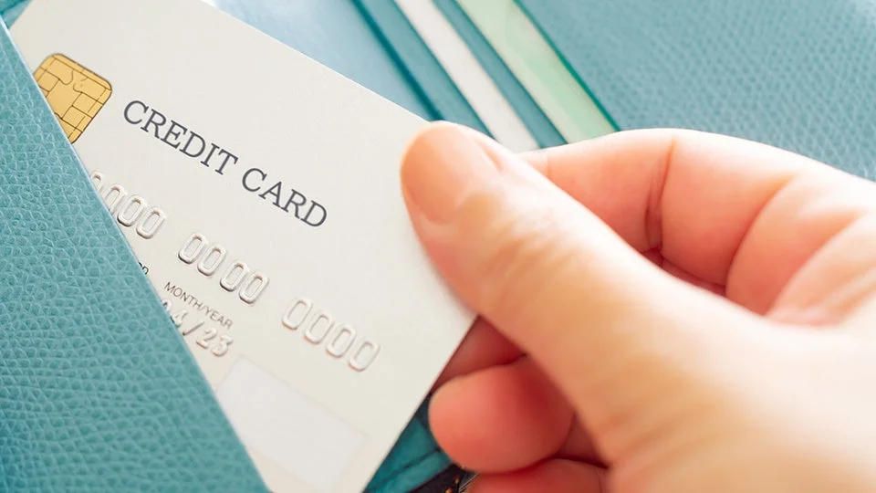 クレジットカードを財布から取り出す手のクローズアップ