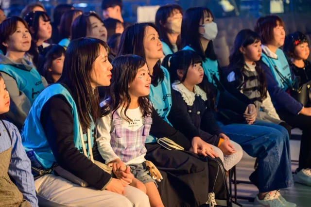 保護者と一緒にTGCのリハーサルを見学する子どもたち