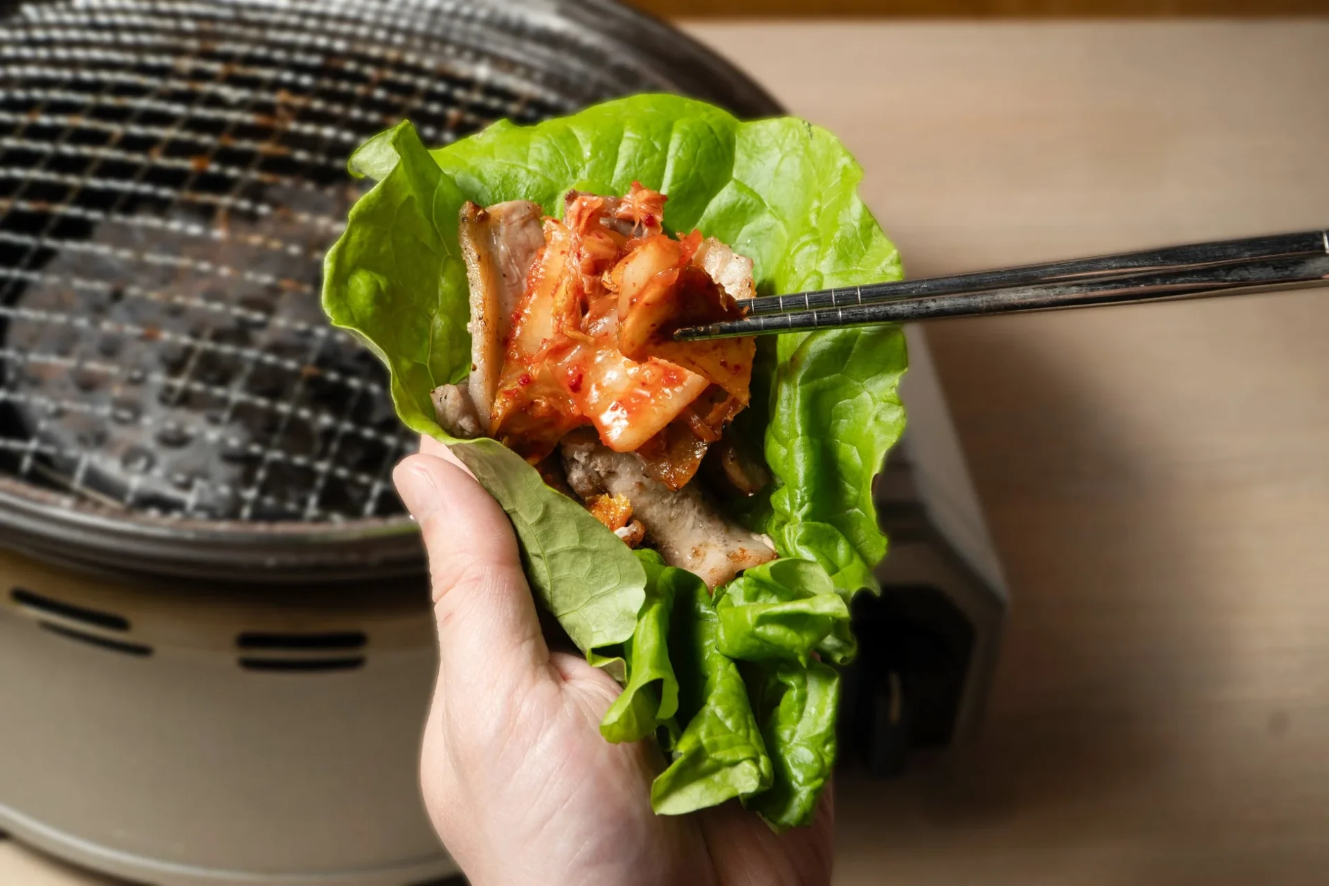 レタスで焼肉とキムチを包んで食べるサムギョプサル