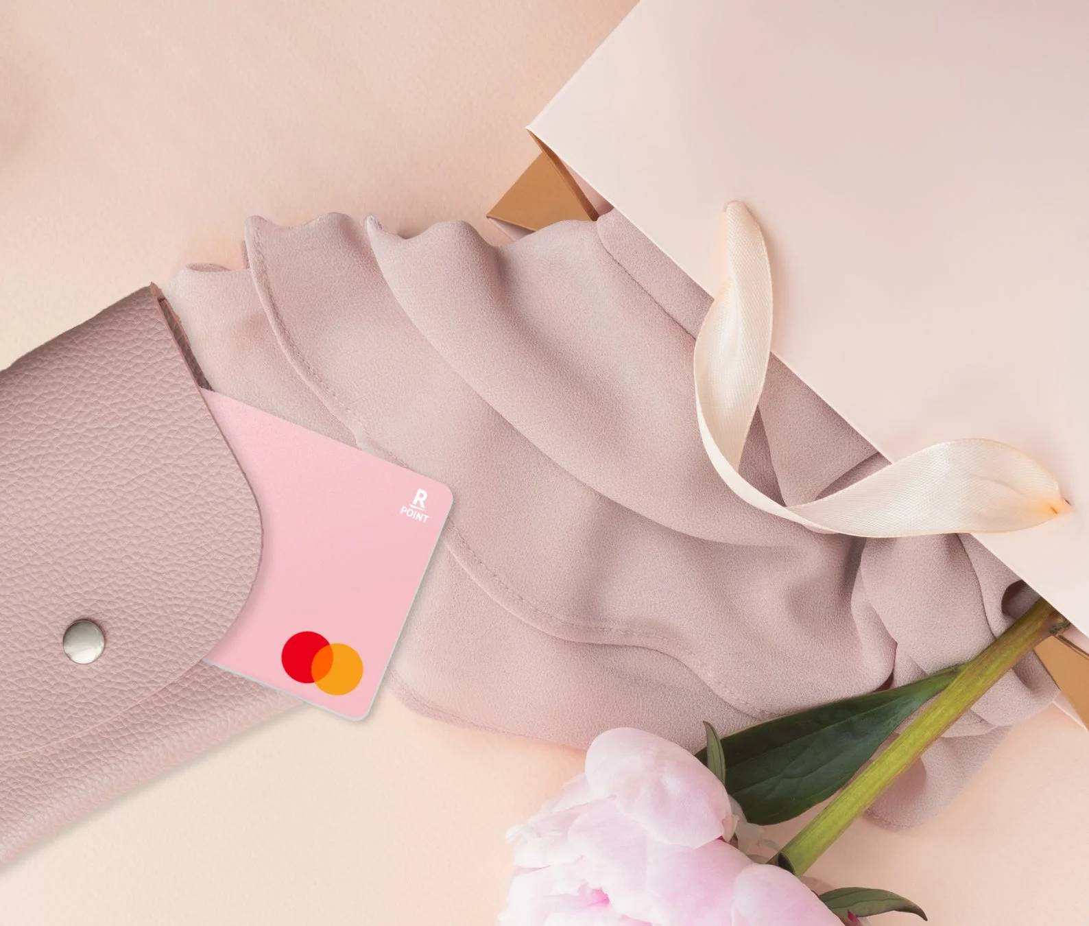 パステルピンクの楽天カードが財布から覗く使用イメージ
