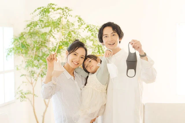 マスクを持ち笑顔で写る家族