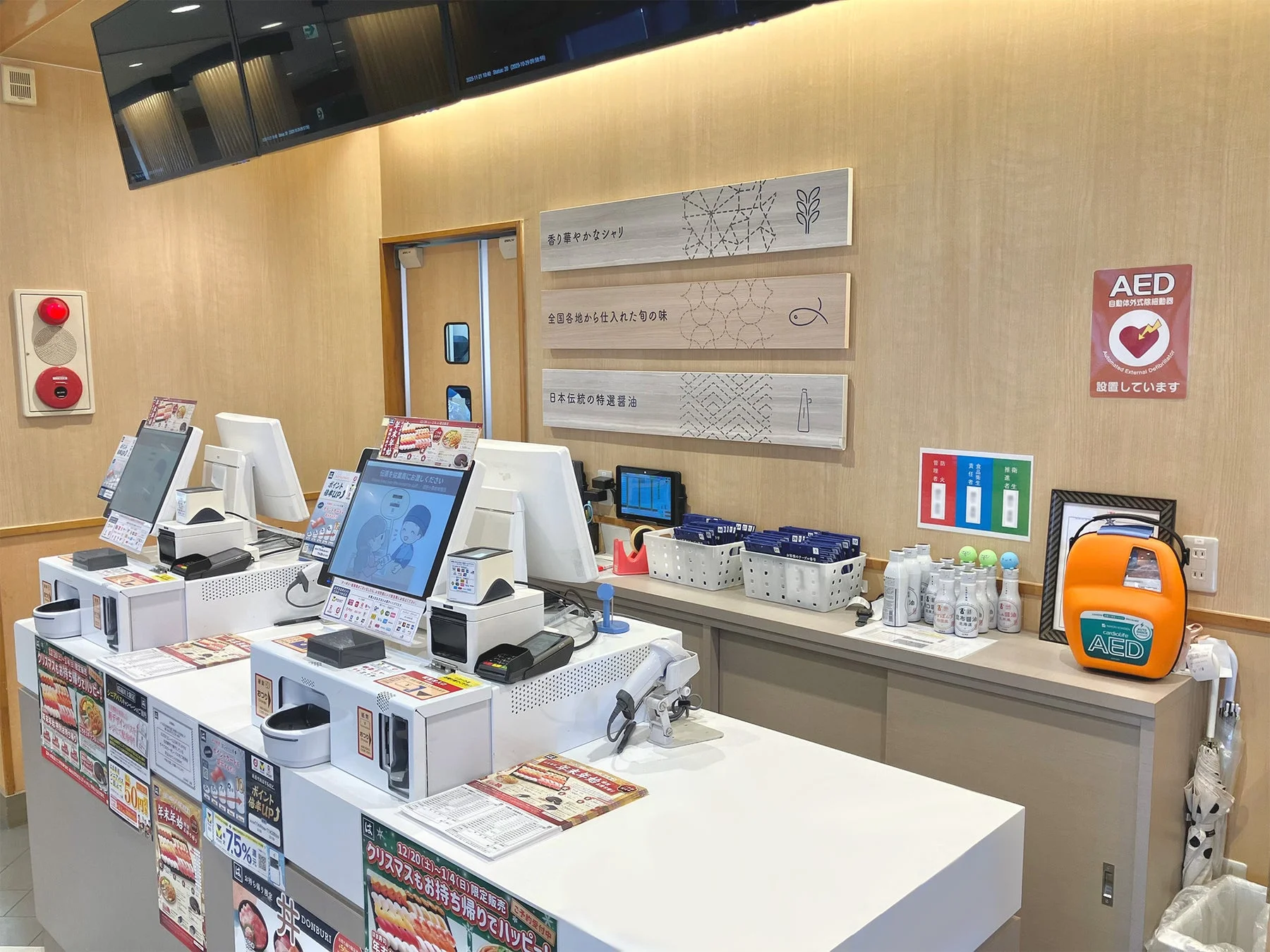 はま寿司店内のレジ横に設置されたAEDと案内ポスター