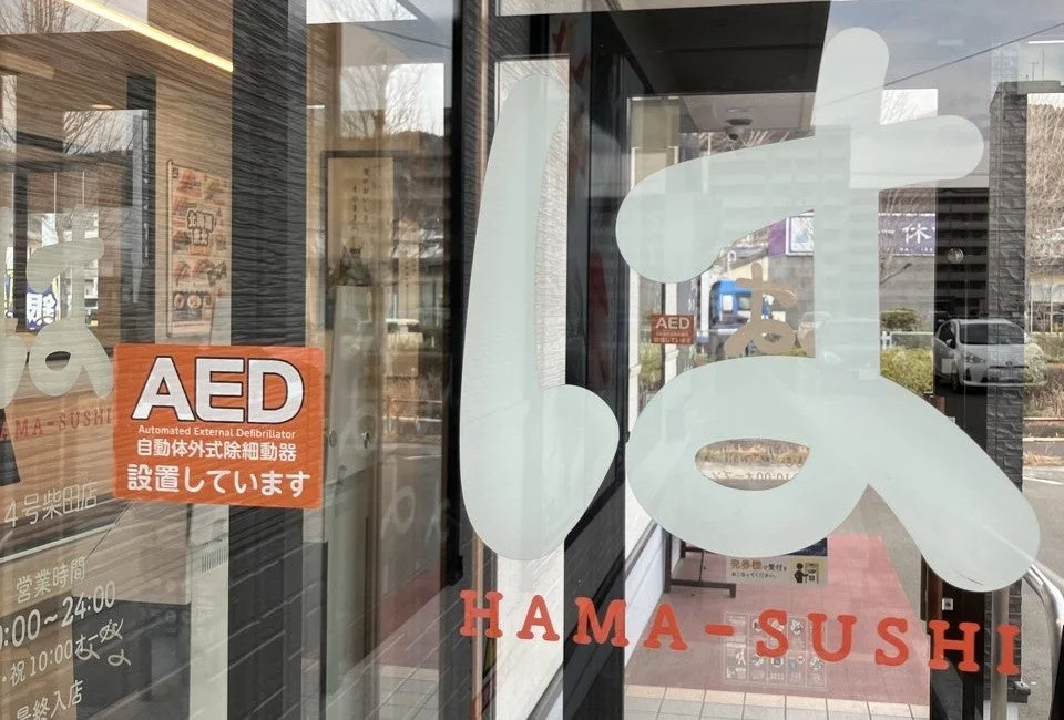 はま寿司の店舗入口に貼られたAED設置を知らせるステッカー