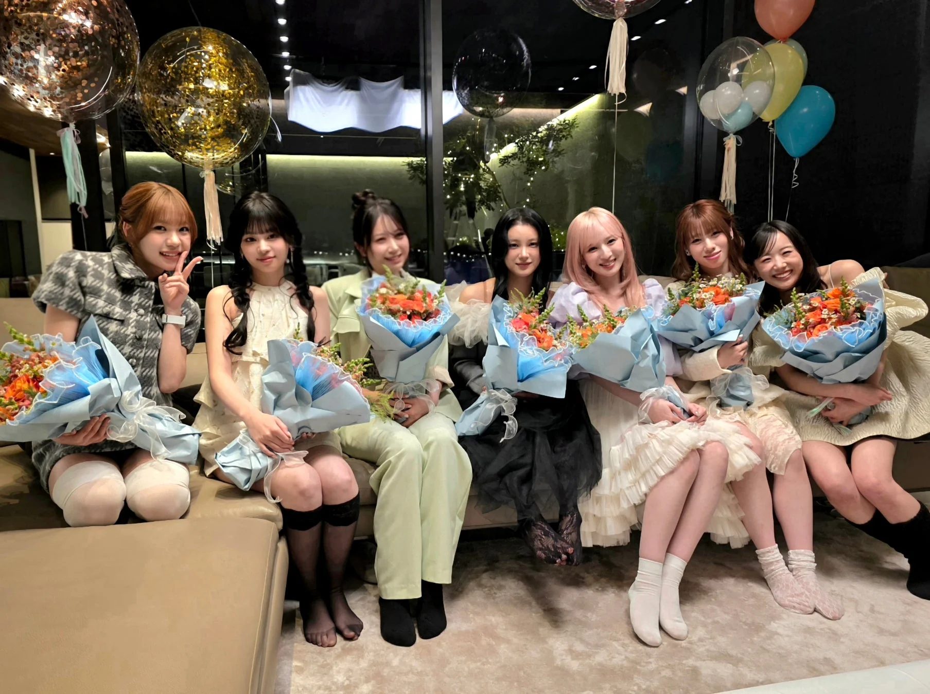 花束を抱えて笑顔を見せるME:Iメンバーの集合写真