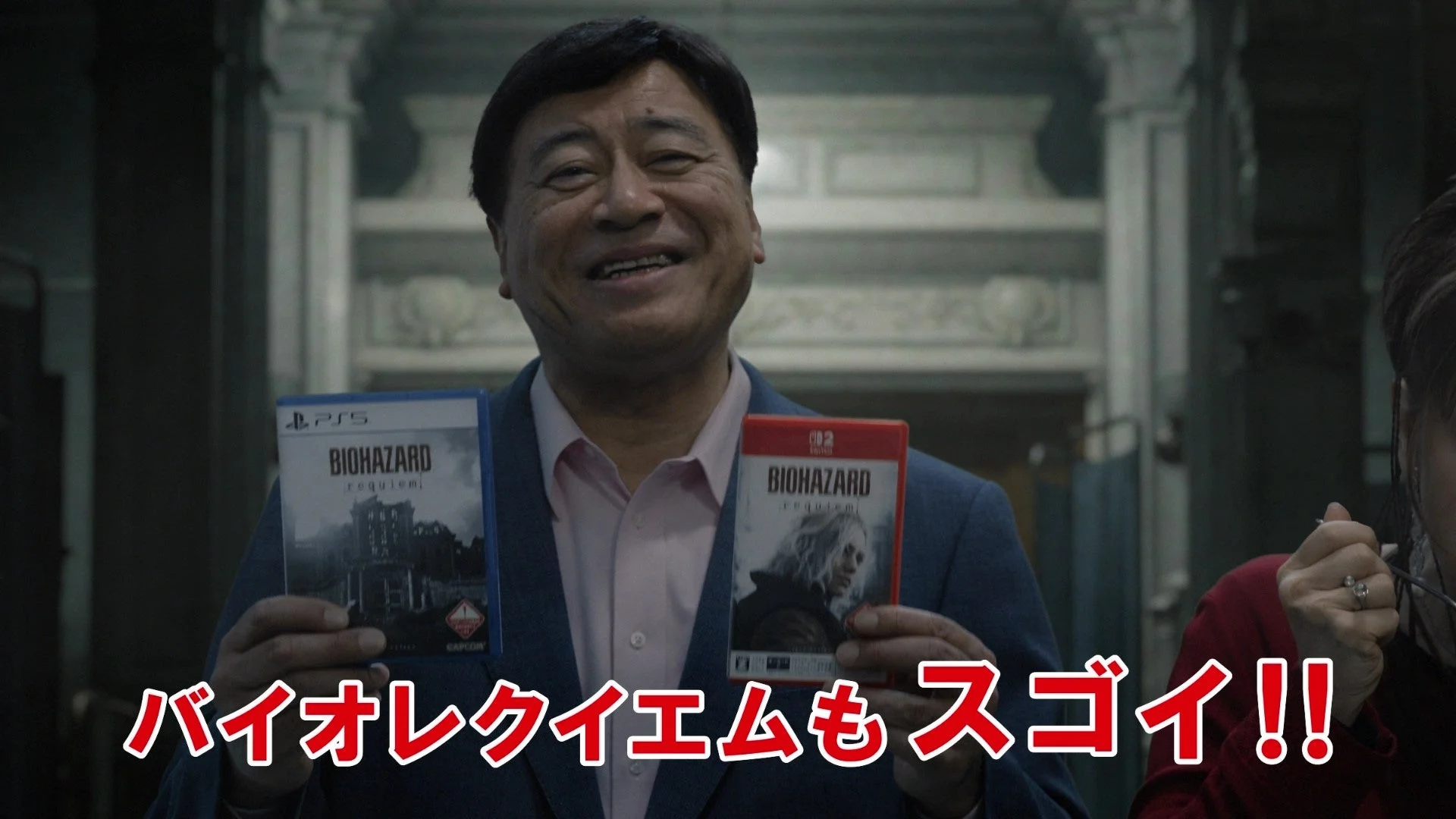 夢グループの石田重廣社長がバイオハザードレクイエムのパッケージを手に笑顔