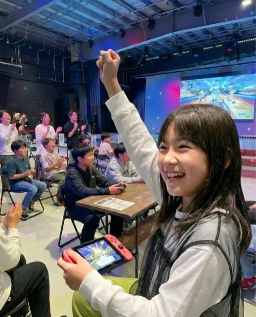 マリオカート大会でコントローラーを握り、ガッツポーズをする子ども