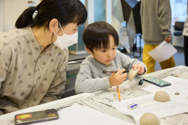 ワークショップ「君だけのモンスターボールをつくろう」に参加する子どもと保護者