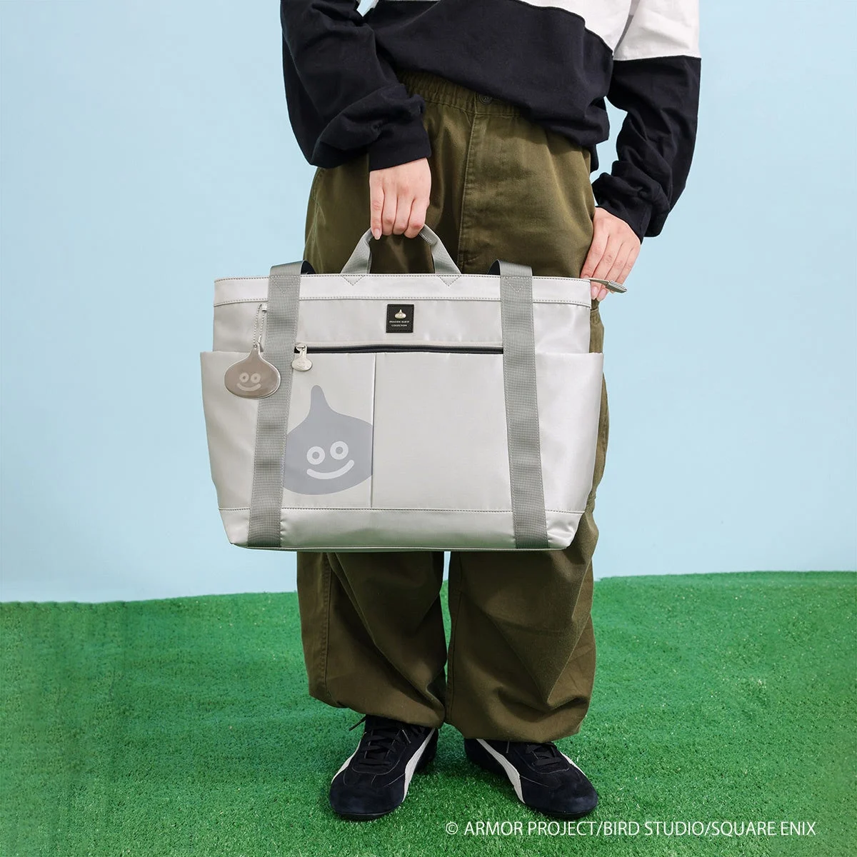 メタルスライムのトートバッグを手に持ったモデル