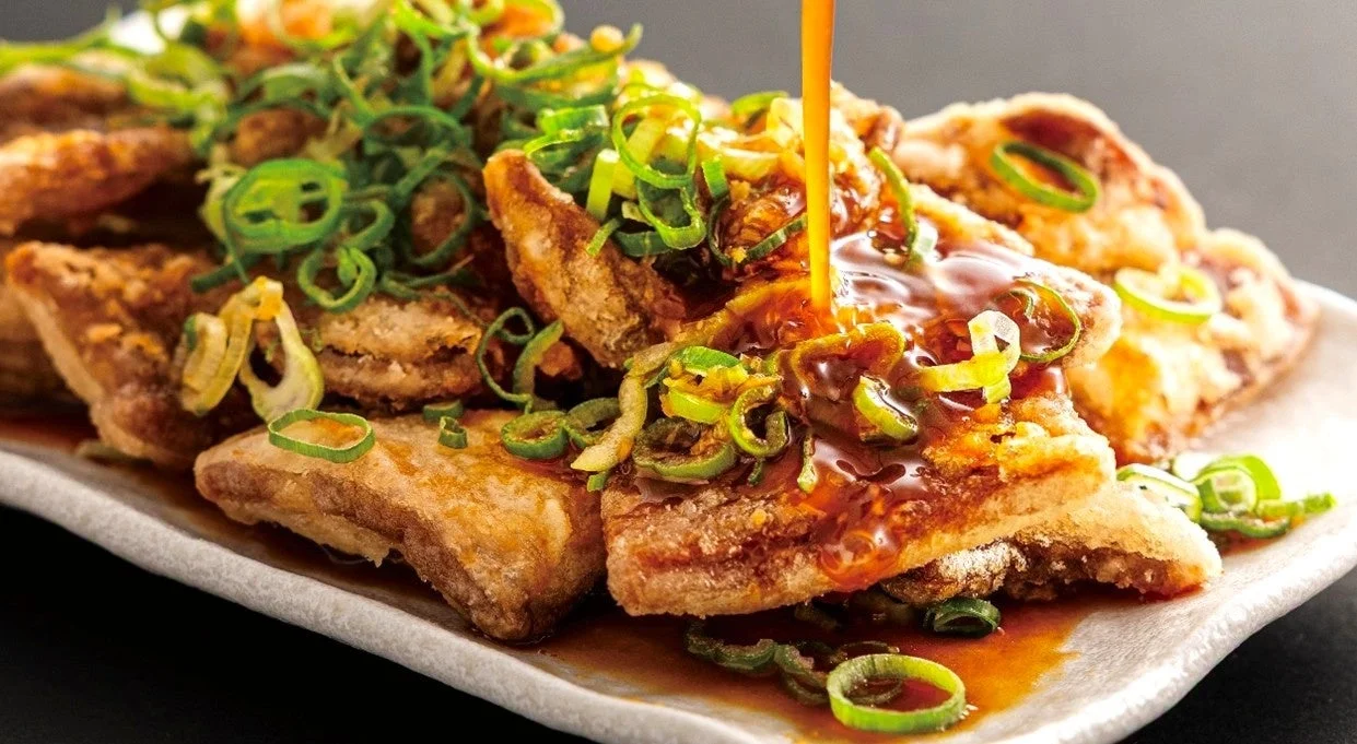 魁力屋の新名物「ぶたから」に特製生姜酢醤油ダレがかかった様子