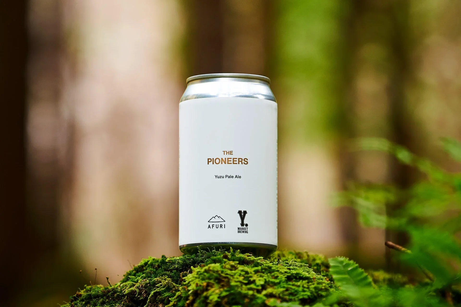 コラボビール「THE PIONEERS」の缶。森の中の苔の上に置かれている。