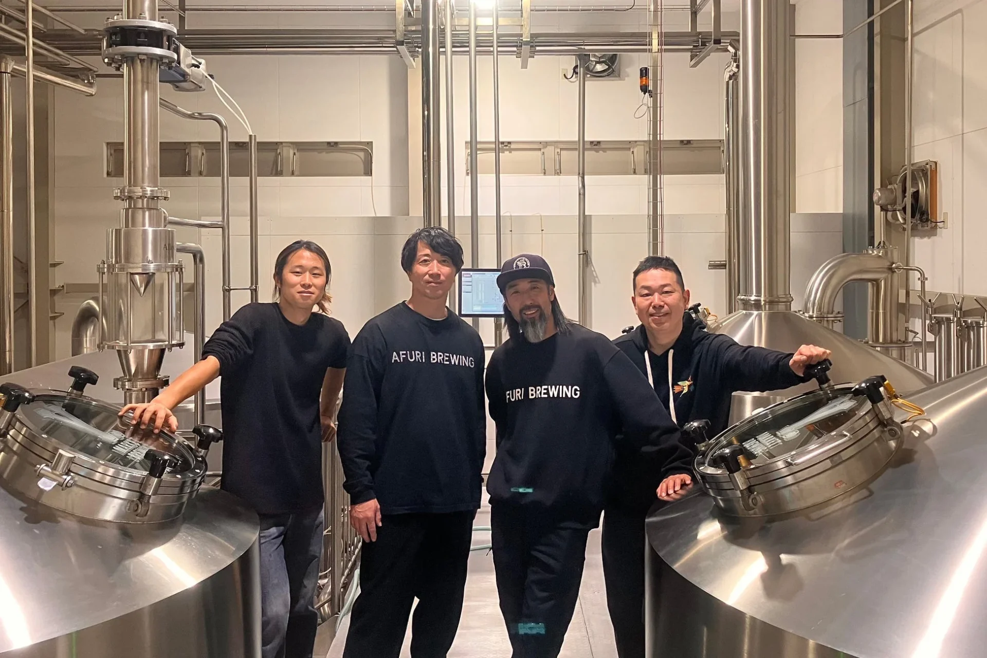AFURI BREWINGとY.MARKET BREWINGの担当者たちがブルワリー内で並ぶ集合写真。